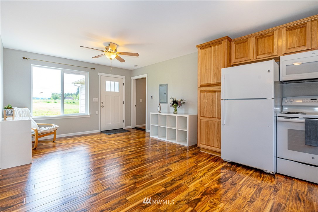 665 Rhoades Road Winlock, WA 98596 - Photo 30 of 39 a view of a kitchen with furniture a ceiling fan and wooden floor
