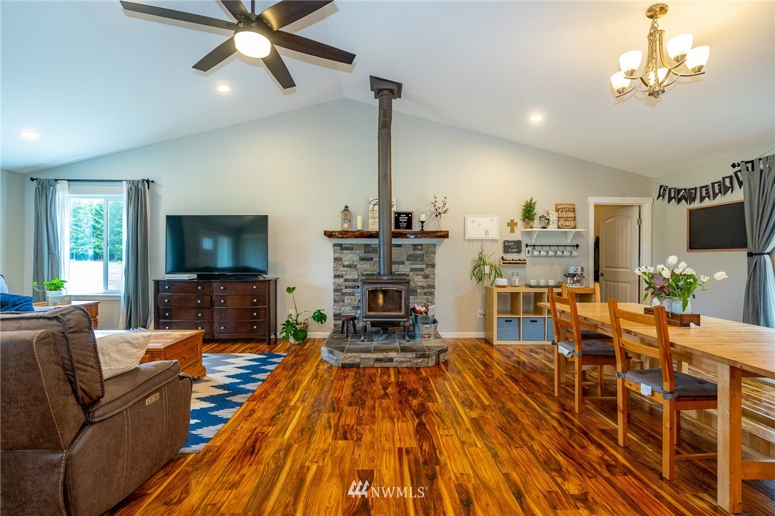 665 Rhoades Road Winlock, WA 98596 - Photo 6 of 39 a living room with furniture a fireplace and a flat screen tv
