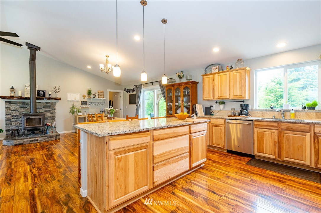 665 Rhoades Road Winlock, WA 98596 - Photo 9 of 39 a kitchen with stainless steel appliances kitchen island granite countertop a stove a sink and white cabinets with wooden floor
