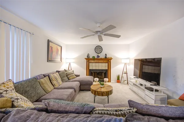 a living room with furniture a flat screen tv and a fireplace