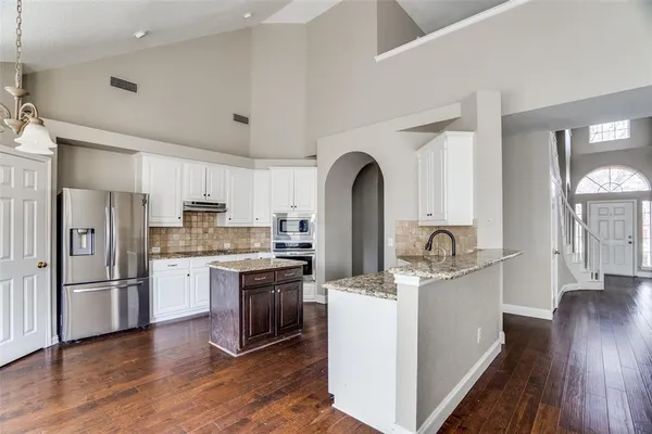 a kitchen with stainless steel appliances granite countertop a refrigerator sink and cabinets