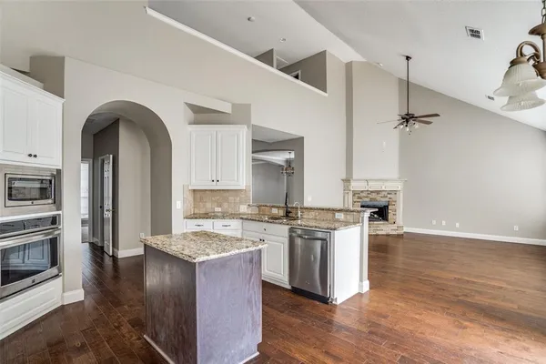 a kitchen with stainless steel appliances granite countertop a stove a sink and a refrigerator