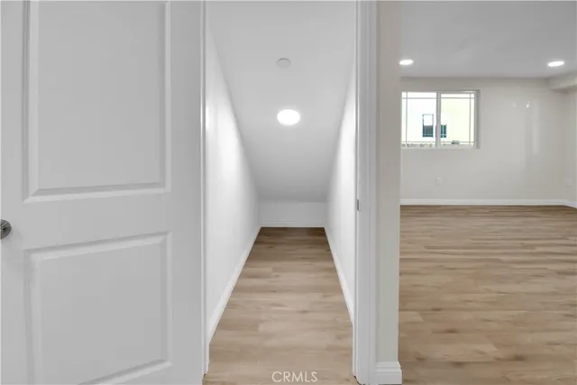a view of a hallway with wooden floor and a window