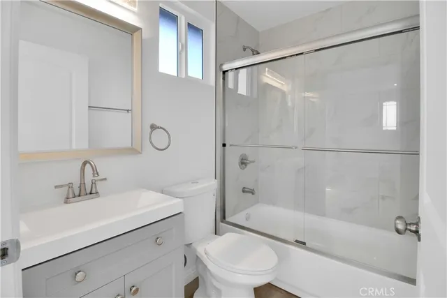 a bathroom with a sink mirror bathtub and toilet