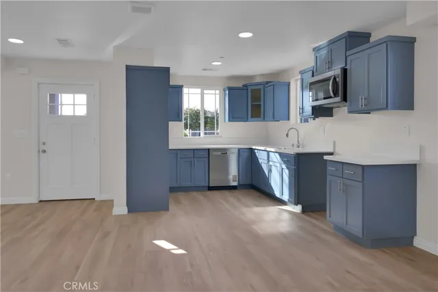 a view of a kitchen with wooden floor and electronic appliances