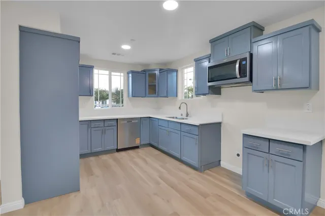 a kitchen with stainless steel appliances granite countertop a sink a stove a microwave a counter top space and cabinets