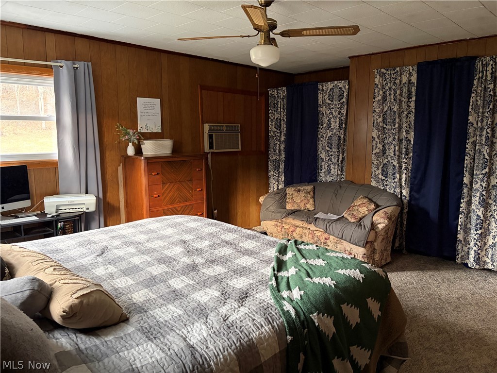 3719 Holmes Road Cambridge, OH 43725 - Photo 16 of 20 Bedroom featuring carpet flooring, ceiling fan, and wooden walls