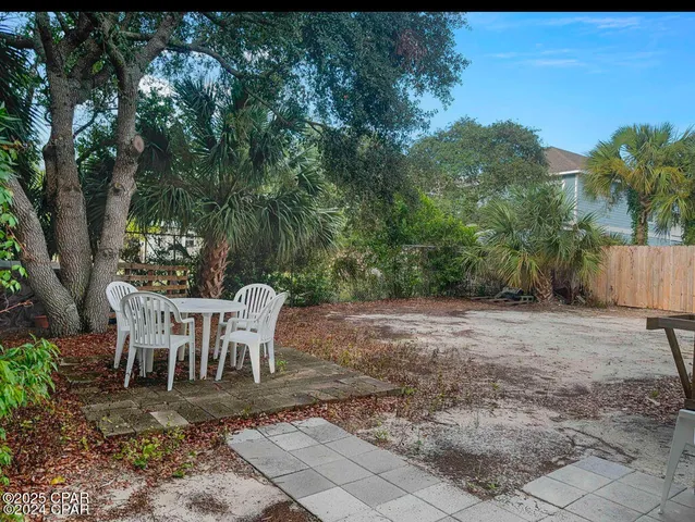a view of a chairs and table in the backyard