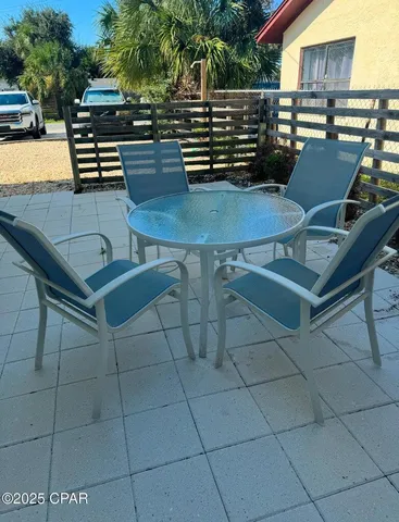 a view of a patio with table and chairs with wooden floor and fence