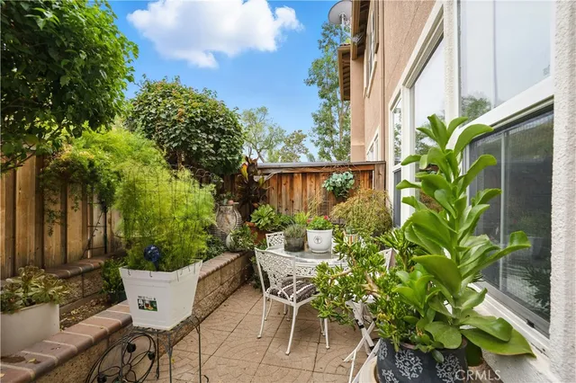 a view of a patio with couches table and chairs and potted plants