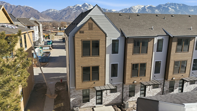 7338 South Seven Tree Lane, Unit 75 Midvale, UT 84047 - Photo 2 of 30 View of front of house with a mountain view, stone siding, a shingled roof, and a residential view