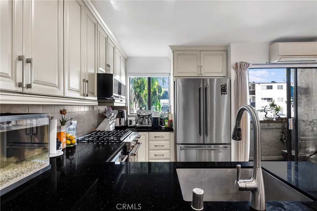 18530 Hatteras Street, Unit 213 Tarzana, CA 91356 - Photo 5 of 17 a kitchen with stainless steel appliances a refrigerator sink and cabinets