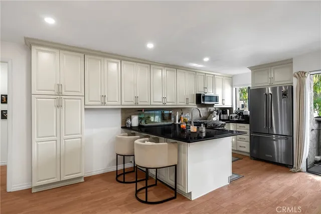 a kitchen with a refrigerator and a stove top oven