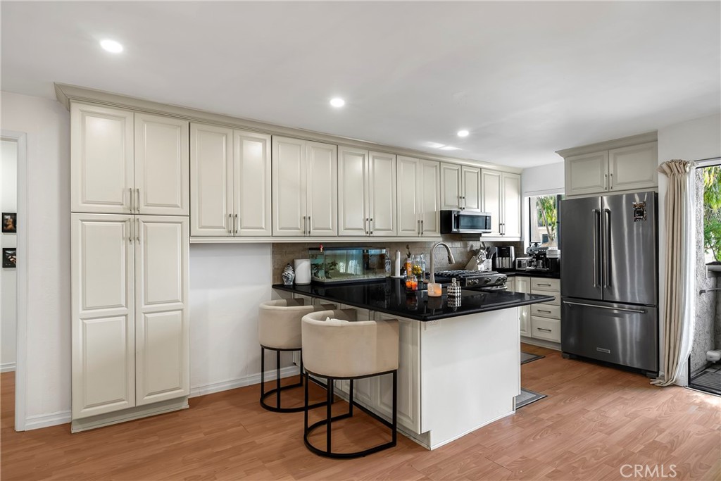 18530 Hatteras Street, Unit 213 Tarzana, CA 91356 - Photo 7 of 17 a kitchen with a refrigerator and a stove top oven