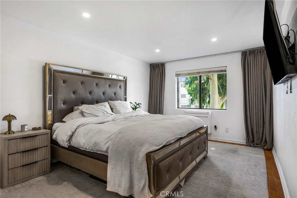 18530 Hatteras Street, Unit 213 Tarzana, CA 91356 - Photo 8 of 17 a bedroom with a bed and a flat tv screen on dresser