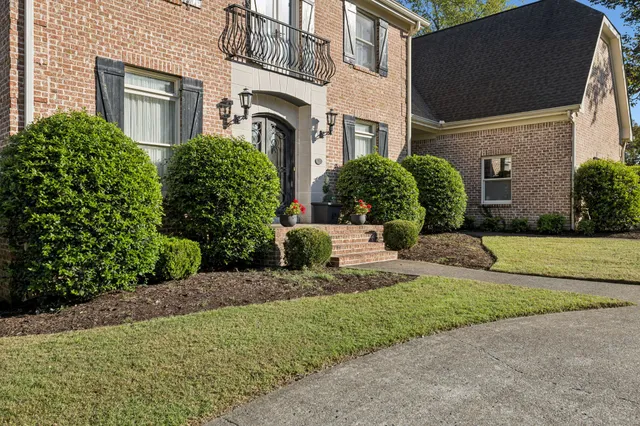 a front view of a house with a garden
