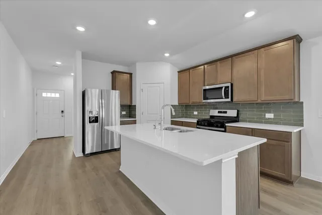 a kitchen with stainless steel appliances a refrigerator sink and microwave