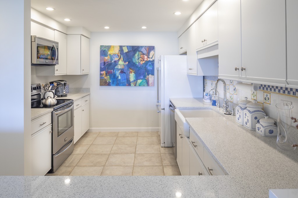 1 Belmont Road, Unit 223 West Harwich, MA 02671 - Photo 6 of 23 a large white kitchen with stainless steel appliances a stove a sink a refrigerator and cabinets