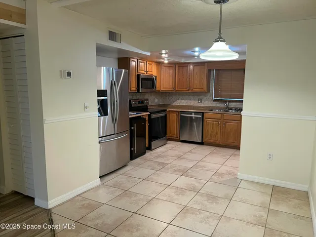 a kitchen with stainless steel appliances granite countertop a refrigerator oven a sink and dishwasher