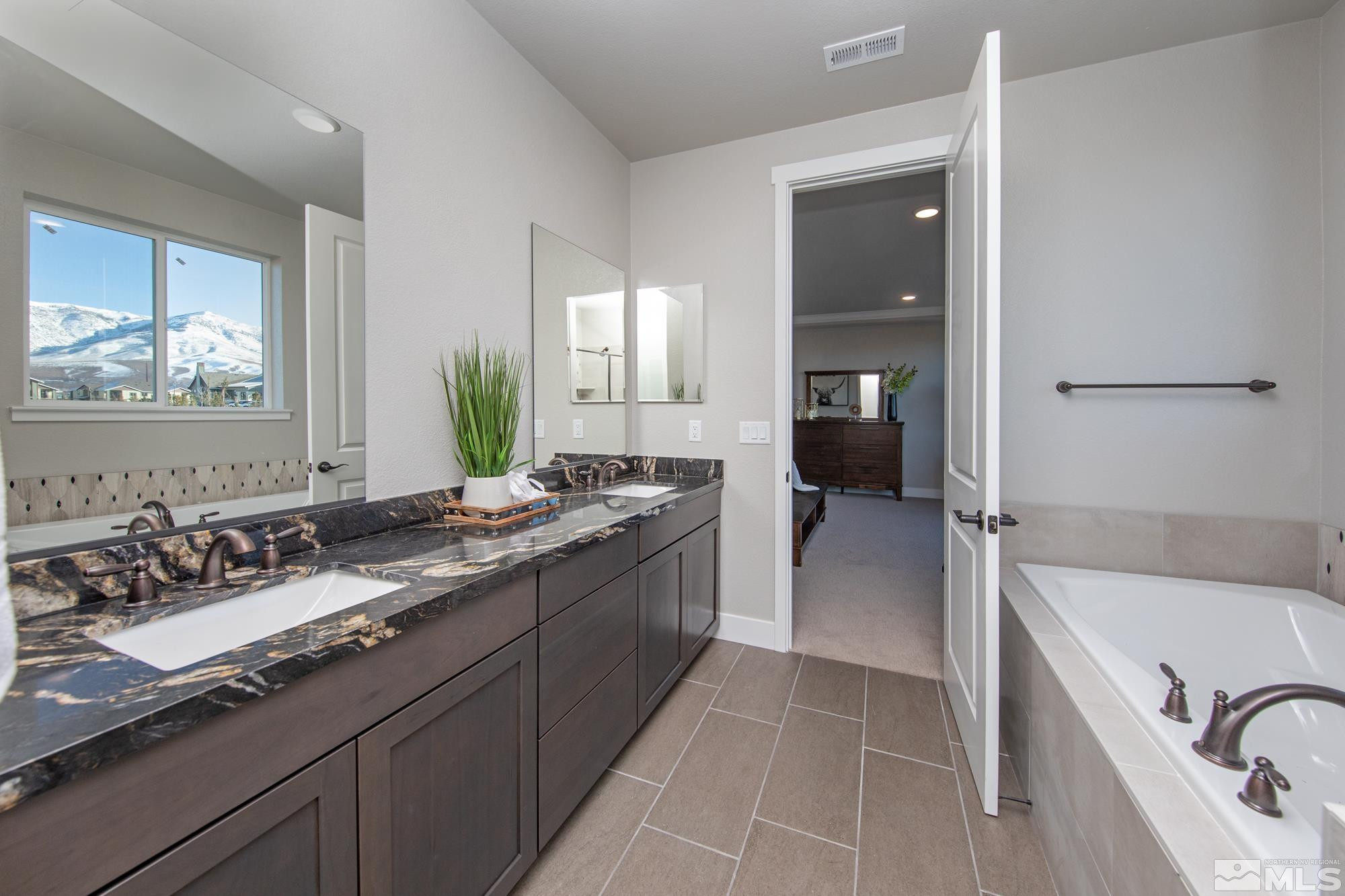 7719 Enclave Key Road Reno, NV 89506 - Photo 10 of 26 a spacious bathroom with a bathtub sink and mirror