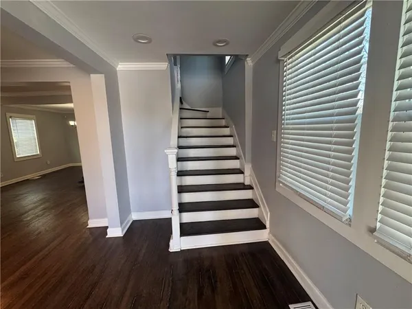 a view of a hallway with wooden floor and windows