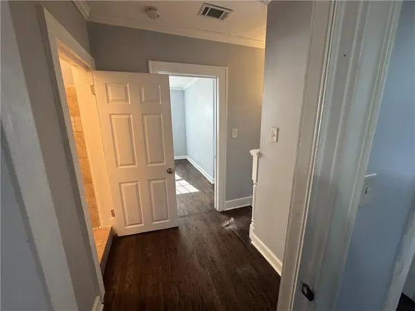 a view of a hallway with wooden floor and staircase
