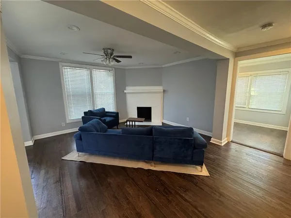 a living room with hard wood floors and a ceiling fan