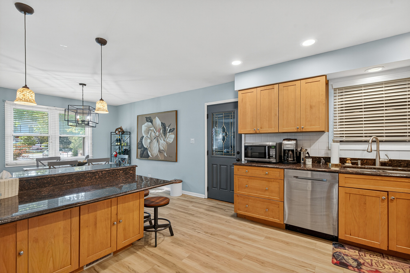 185 North Happ Road Northfield, IL 60093 - Photo 14 of 38 a kitchen with stainless steel appliances granite countertop wooden floors and white cabinets