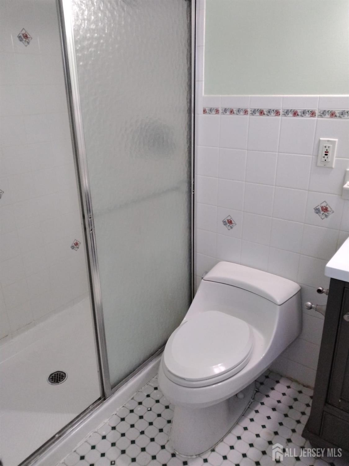 363 Cranbury Road, Unit A16 East Brunswick, NJ 08816 - Photo 11 of 12 a white toilet sitting next to a sink a bath tub and a shower