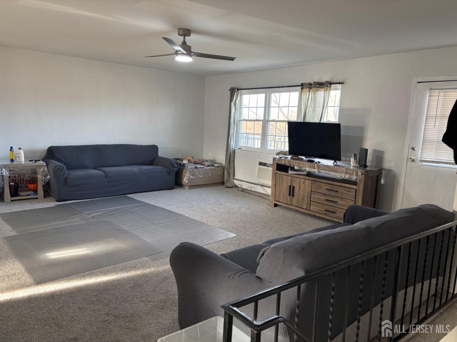 363 Cranbury Road, Unit A16 East Brunswick, NJ 08816 - Photo 5 of 12 a living room with furniture and a flat screen tv