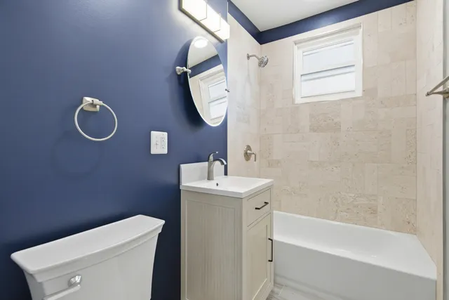 a bathroom with a toilet a sink and mirror