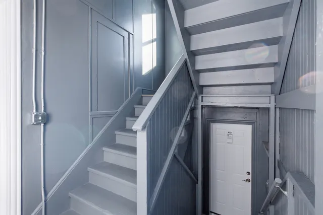a view of staircase with white walls and wooden floor