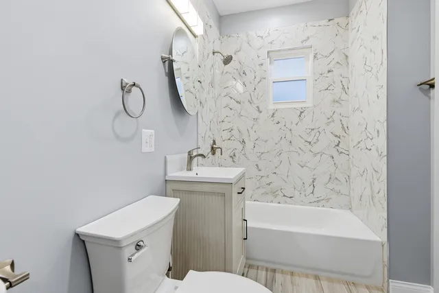 a bathroom with a sink a toilet and shower