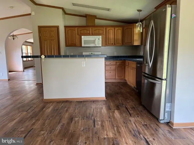 a kitchen with granite countertop wooden floors and stainless steel appliances