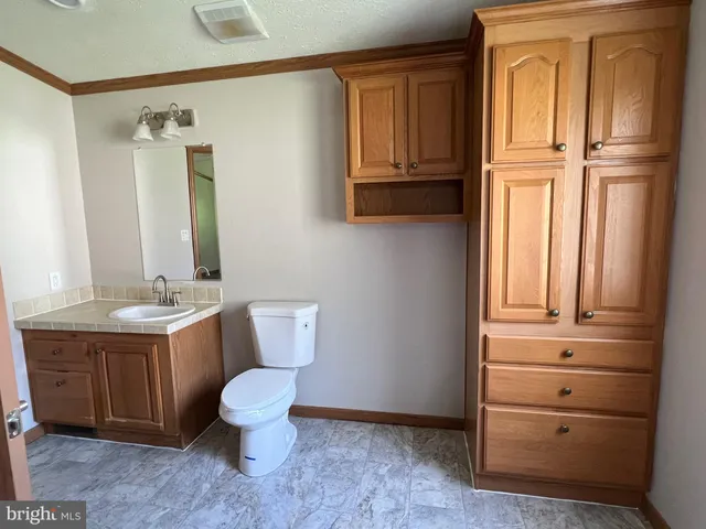 a bathroom with a toilet sink and mirror