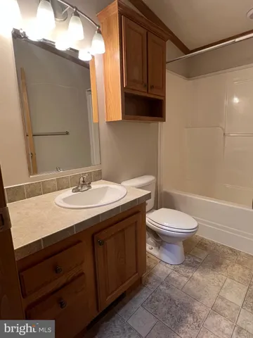 a bathroom with a granite countertop sink toilet and a mirror