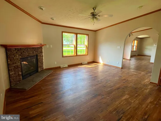 a view of an empty room with a fireplace and a window