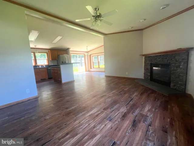 a view of a livingroom with a fireplace wooden floor and a window