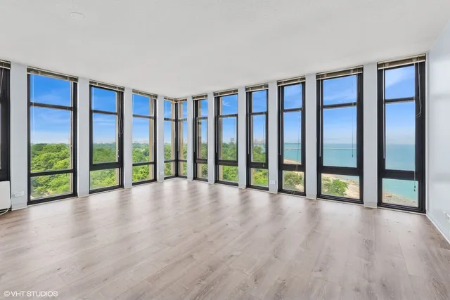 a view of an empty room with window wooden floor and door