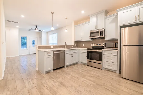 a kitchen with white cabinets and stainless steel appliances