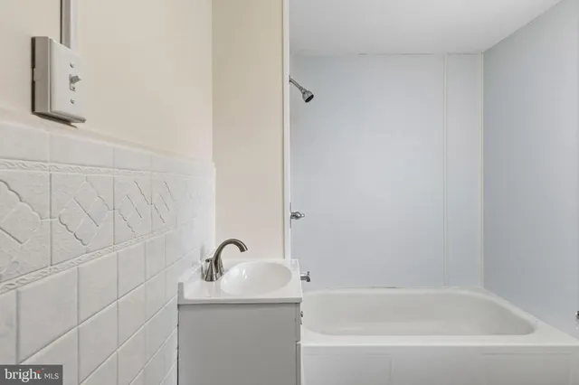 a view of an empty room with wooden floor and windows
