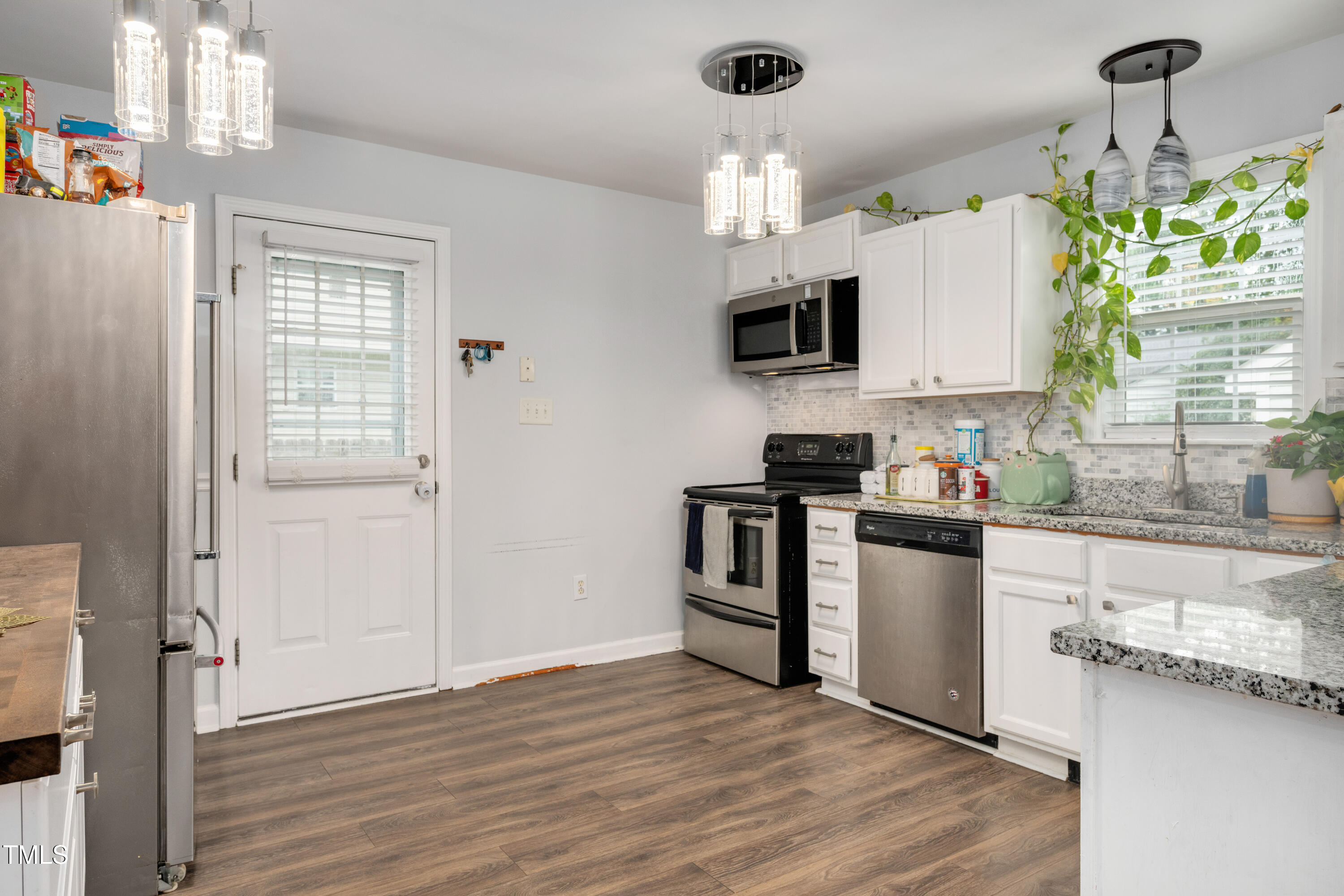 4809 Hallam Way Raleigh, NC 27616 - Photo 6 of 30 a kitchen with granite countertop a stove a sink and a refrigerator
