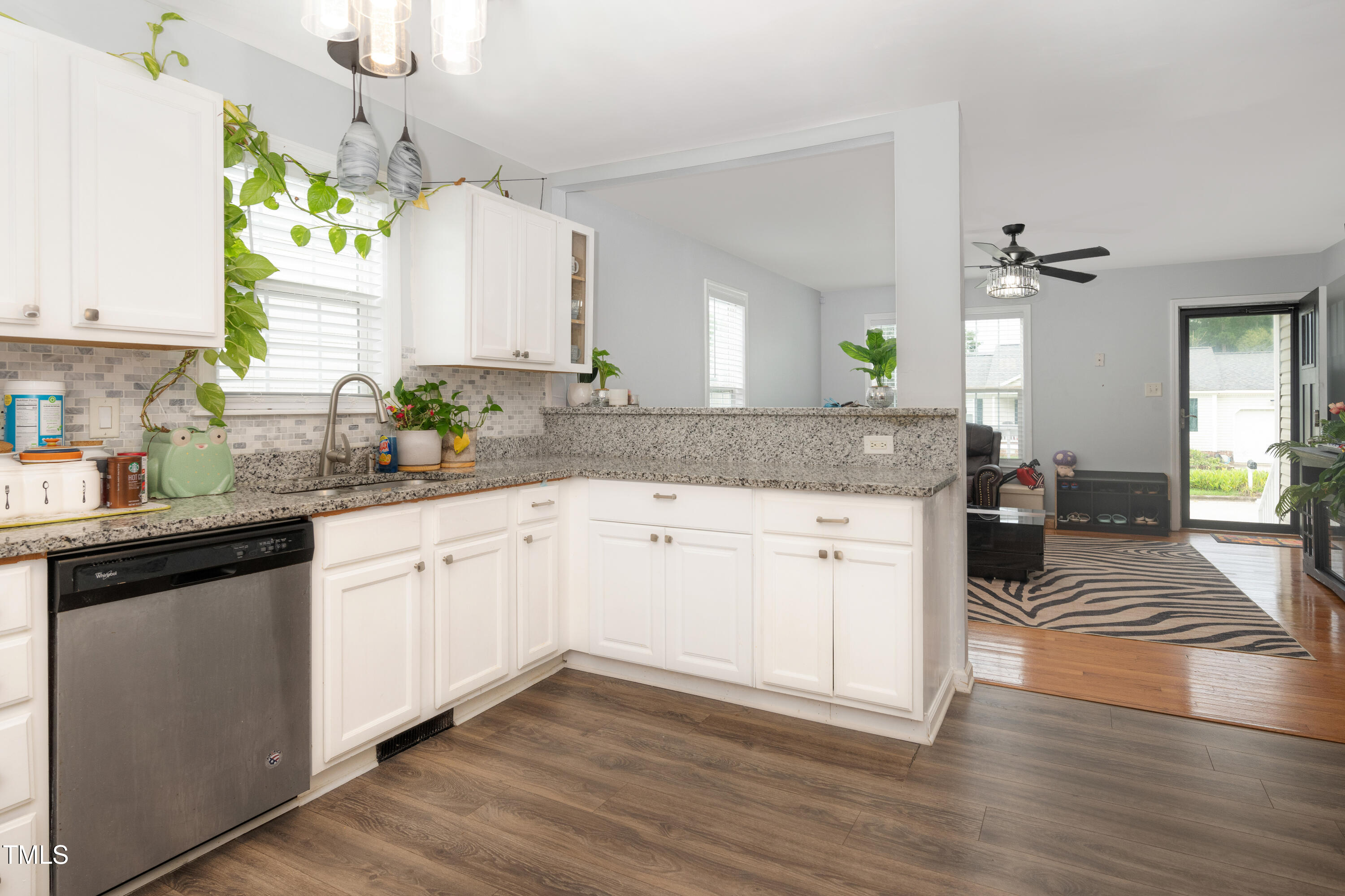 4809 Hallam Way Raleigh, NC 27616 - Photo 7 of 30 a kitchen with a sink dishwasher and white cabinets with wooden floor