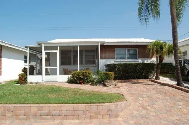 a front view of a house with a yard and potted plants