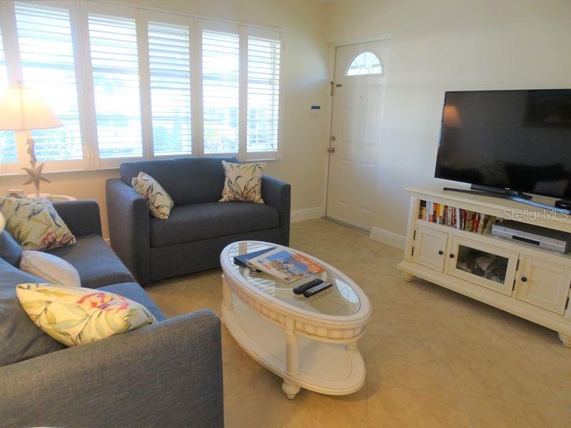 6020 Midnight Pass Road, Unit 3 Sarasota, FL 34242 - Photo 2 of 13 a living room with furniture and a flat screen tv