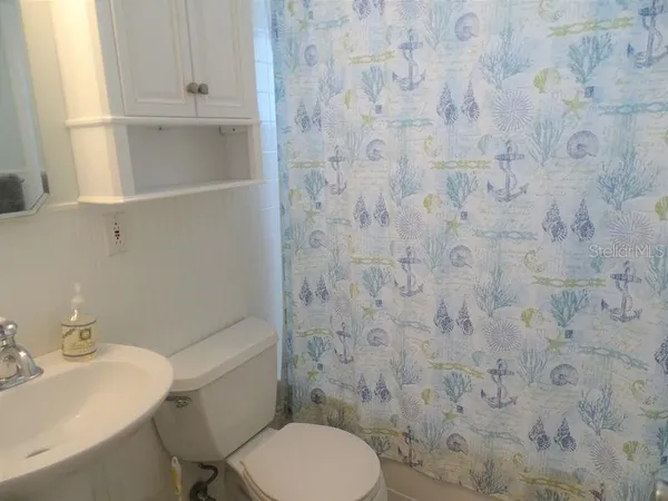 a white toilet sitting next to a white sink