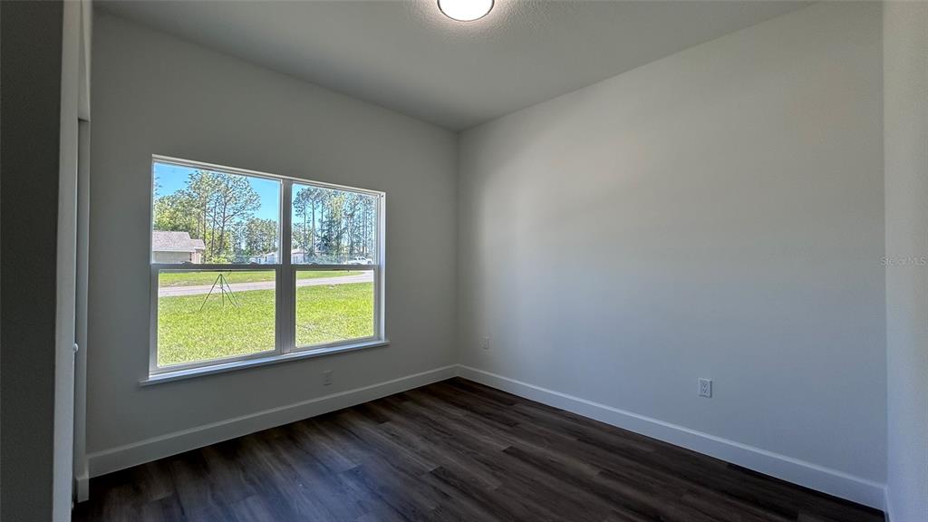 7191 Southwest 133rd Lane Ocala, FL 34473 - Photo 12 of 20 an empty room with wooden floor and windows