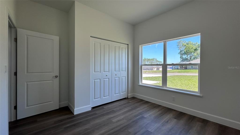 7191 Southwest 133rd Lane Ocala, FL 34473 - Photo 13 of 20 an empty room with wooden floor cabinet and windows