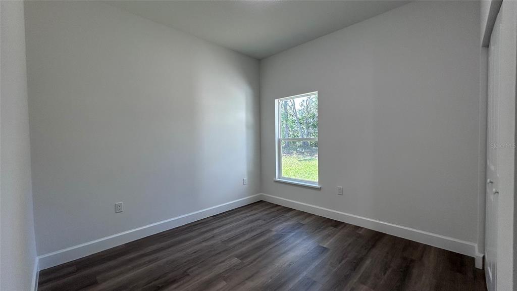 7191 Southwest 133rd Lane Ocala, FL 34473 - Photo 16 of 20 an empty room with wooden floor and windows