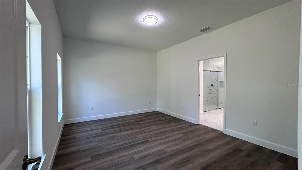 7191 Southwest 133rd Lane Ocala, FL 34473 - Photo 18 of 20 an empty room with wooden floor and windows